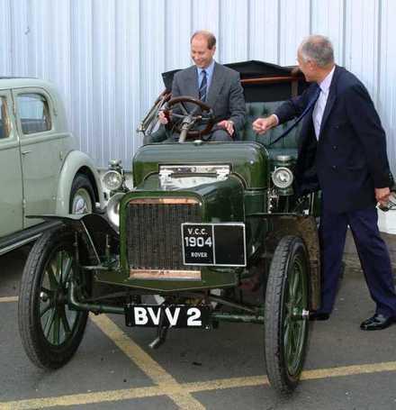 <I> Prins Edward testsitter en av de allra frst byggda roverbilarna, en Rover 8hp frn 1904. Bilens gare, Kent Robinson, frklarar bilens egenskaper.</I>